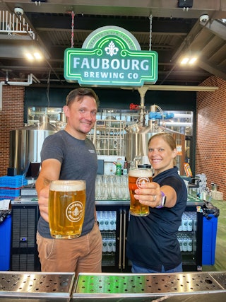 man and woman serving beer in taproom
